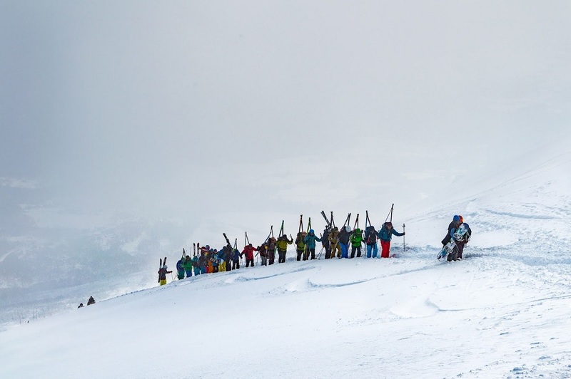 Single-file lines wind their way towards the peak, Mount Annupuri.